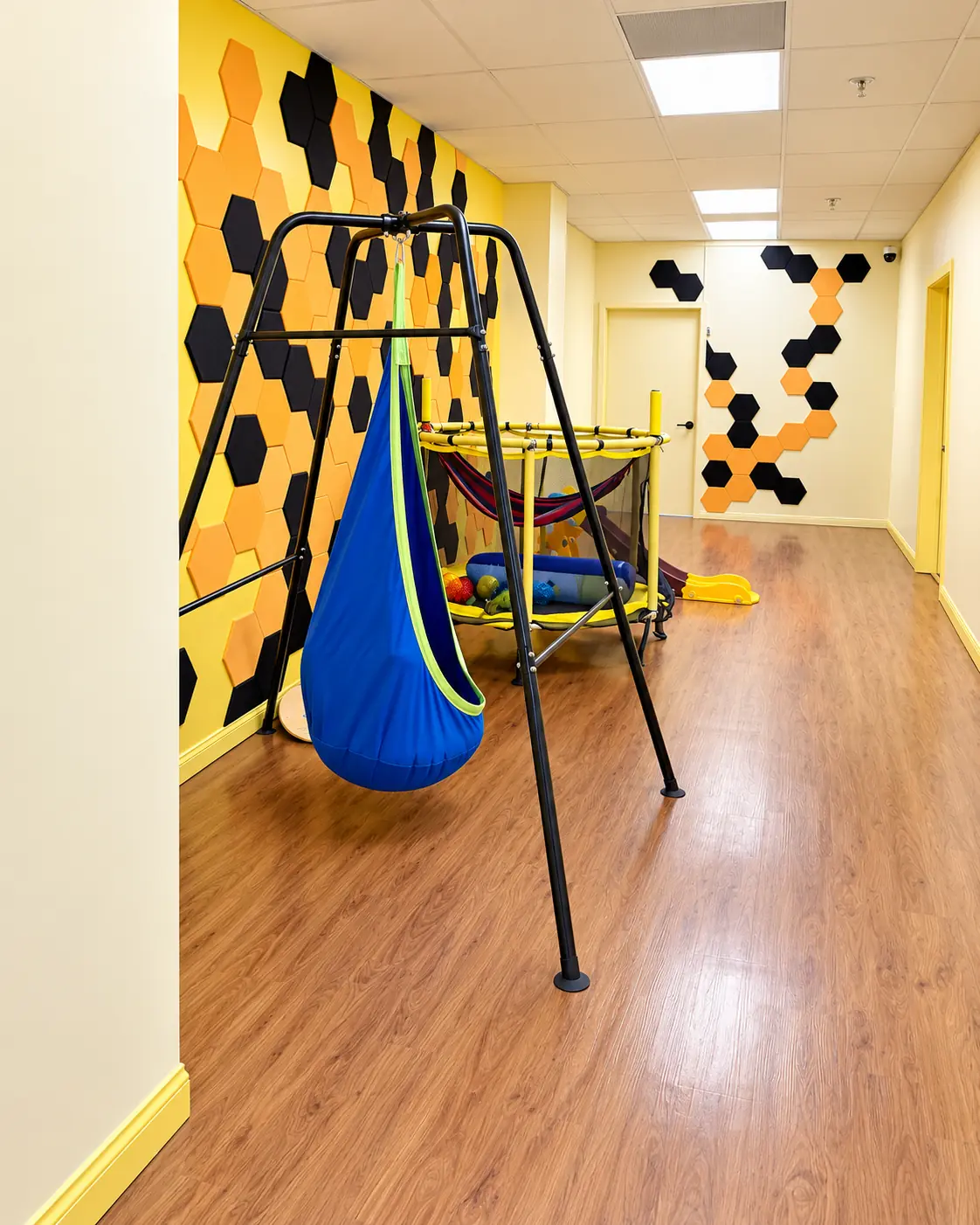 The play area at our Van Nuys clinic, with a hanging swing pod and honeycomb wall panels